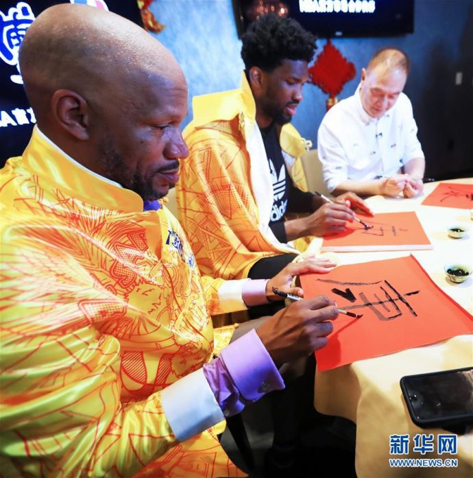 2月15日，传奇球星罗恩·哈珀（左）和NBA费城76人队球星恩比德（中）练习中国书法。新华社记者李颖